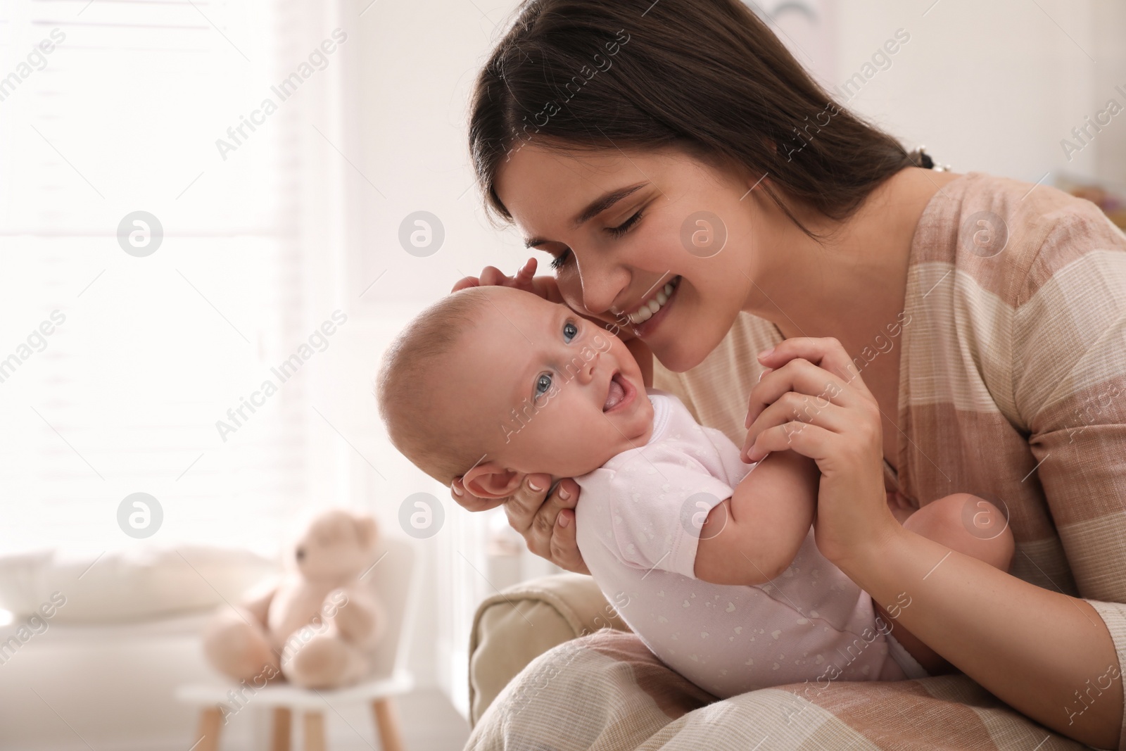 Photo of Happy young mother with her cute baby at home