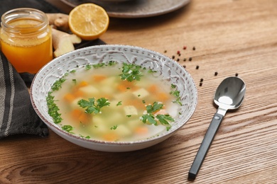 Bowl of fresh homemade soup to cure flu on wooden table