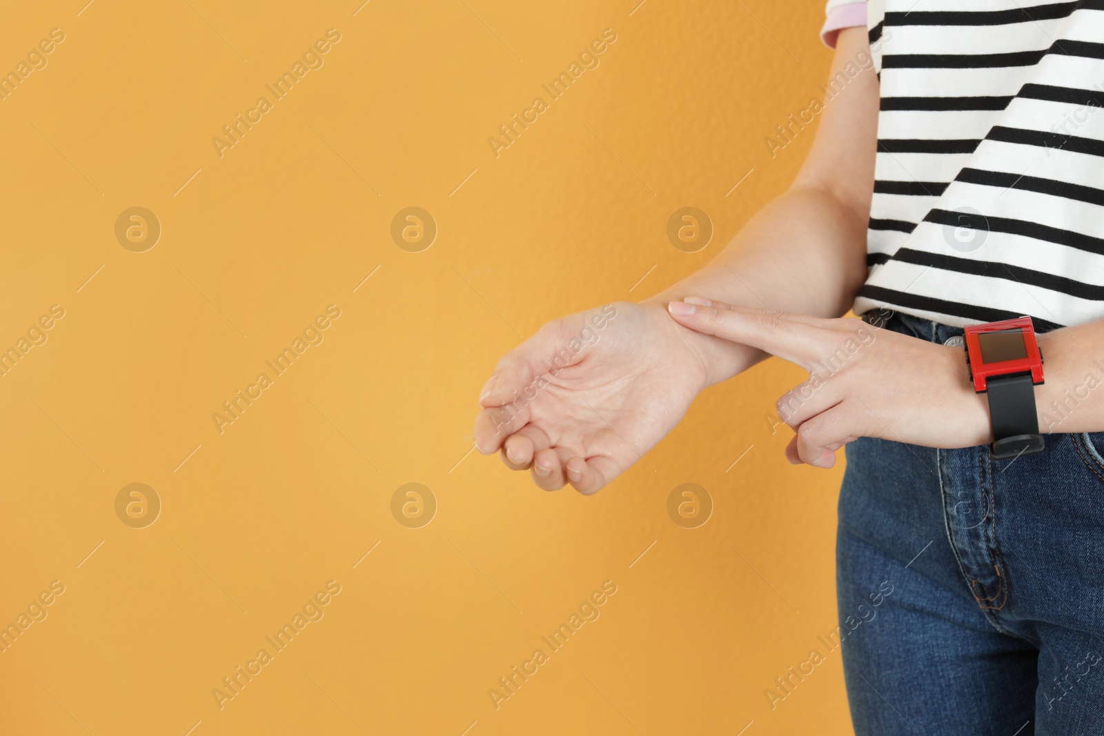 Photo of Woman checking pulse against color background, closeup. Space for text