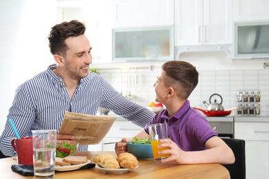 Dad and son having breakfast together in kitchen