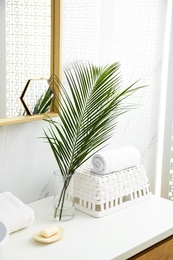 Photo of Tropical palm leaves in stylish bathroom interior