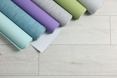 Photo of Different wallpaper rolls on floor, top view. Space for text