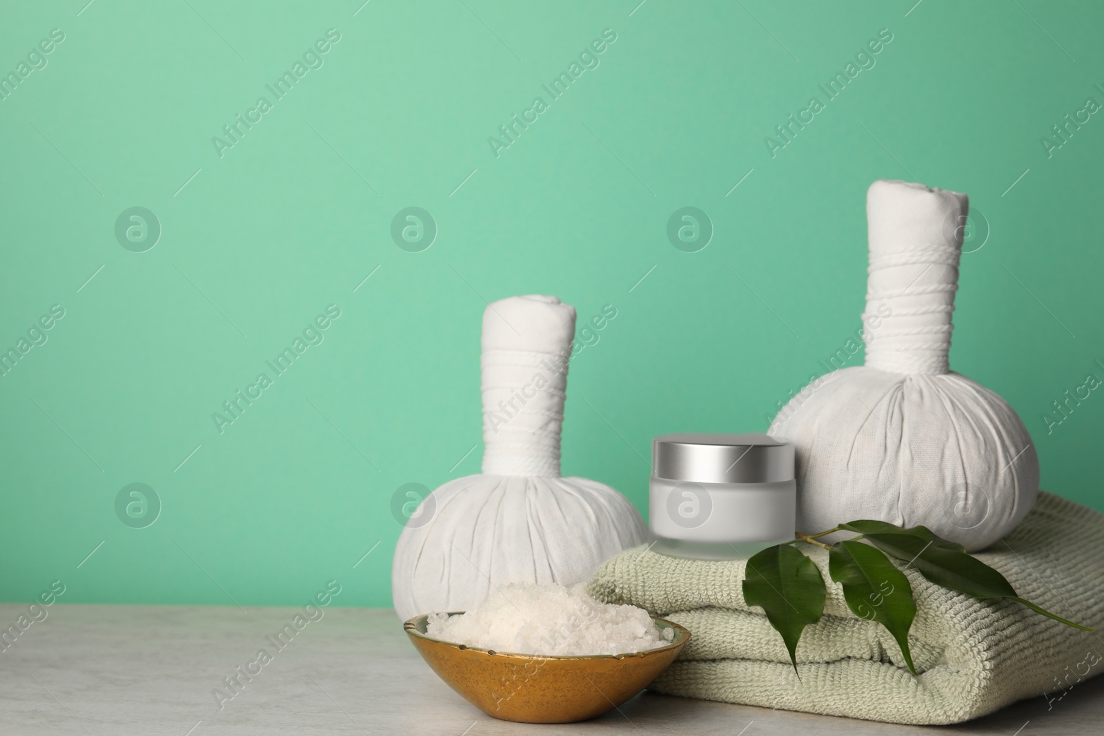 Photo of Composition with different spa products on beige table against turquoise background. Space for text