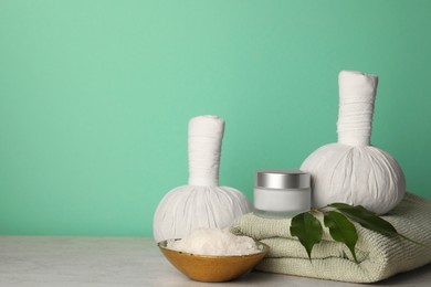 Photo of Composition with different spa products on beige table against turquoise background. Space for text