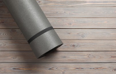 Photo of One yoga mat on wooden floor, top view. Space for text