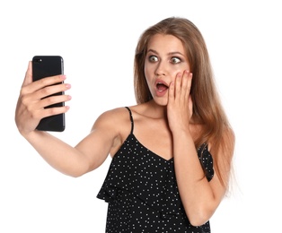 Photo of Surprised young woman taking selfie on white background