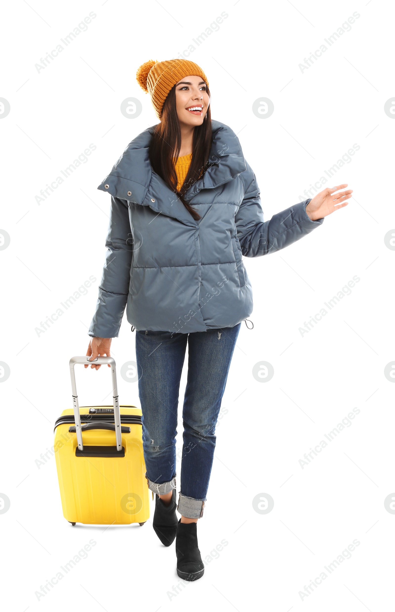 Photo of Young woman in warm clothes with suitcase on white background. Winter vacation