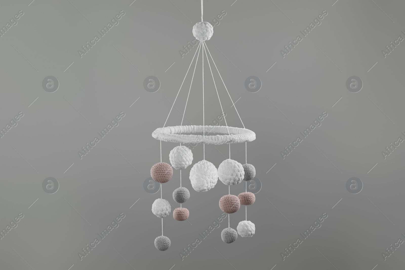 Photo of Cute baby crib mobile on grey background