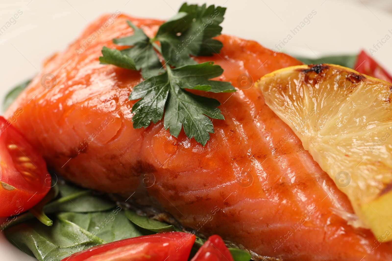 Photo of Tasty grilled salmon with tomatoes, lemon and basil, closeup