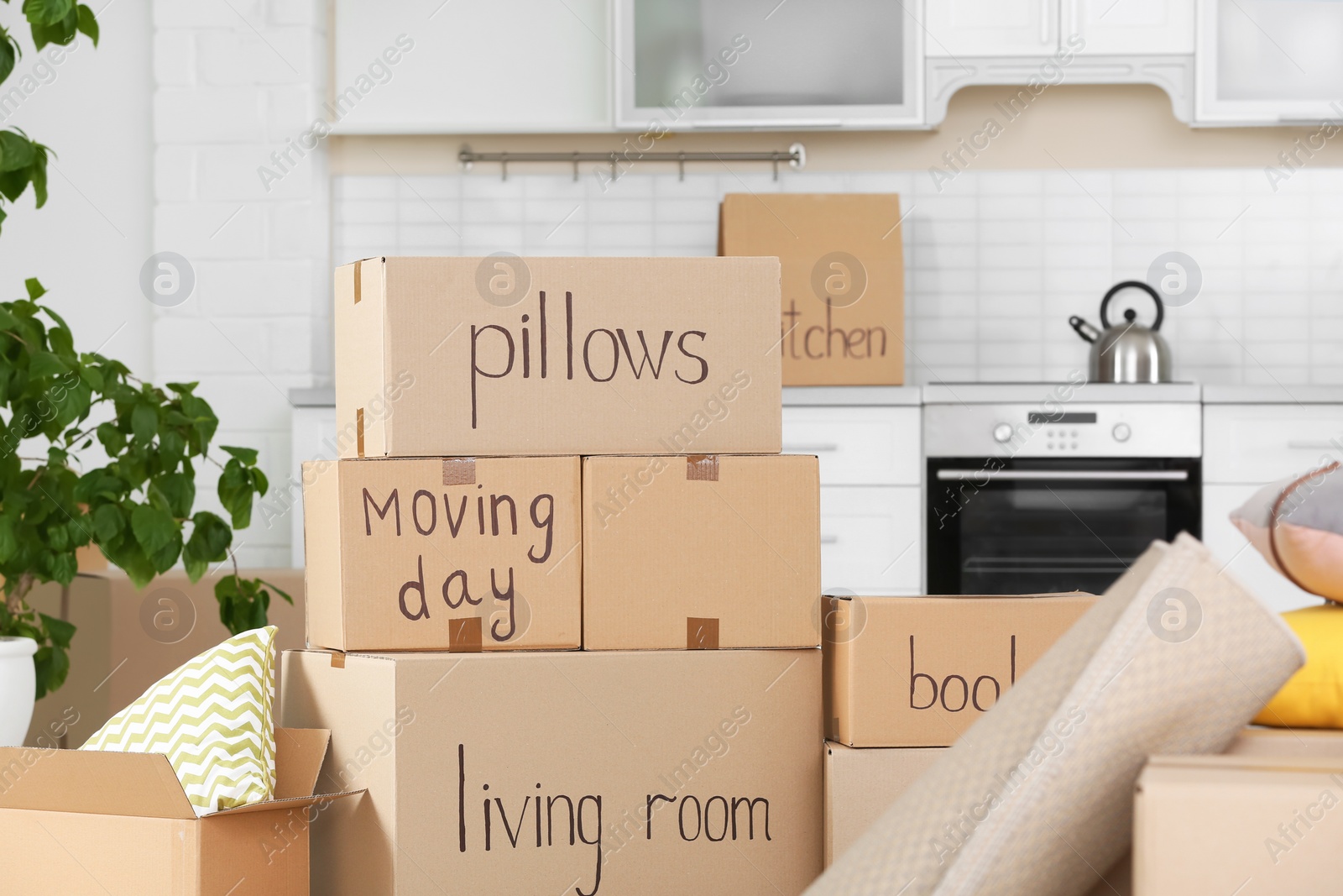 Photo of Cardboard boxes and household stuff in kitchen. Moving day