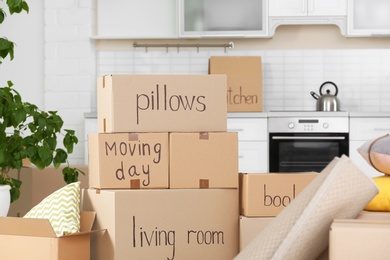 Photo of Cardboard boxes and household stuff in kitchen. Moving day