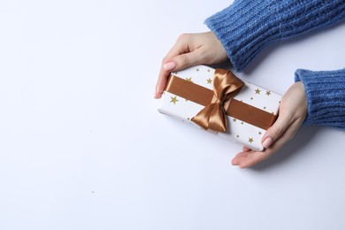 Photo of Christmas present. Woman holding gift box on white background, top view. Space for text