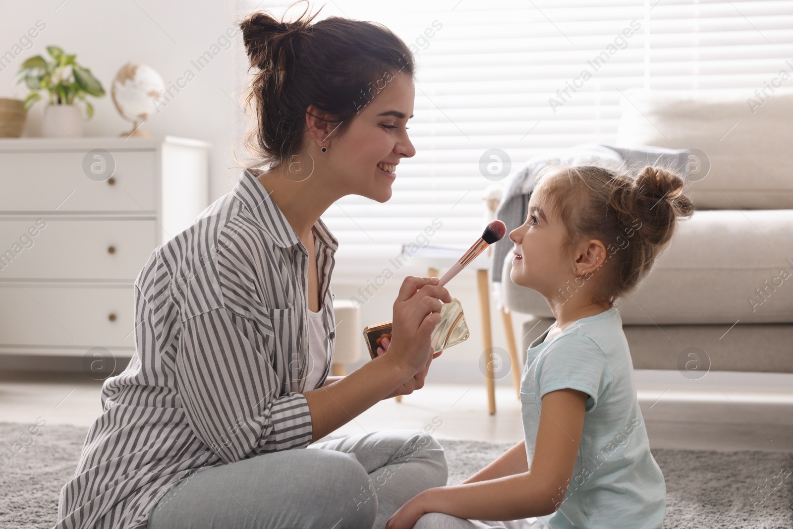 Photo of Young mother and her daughter spending time together at home