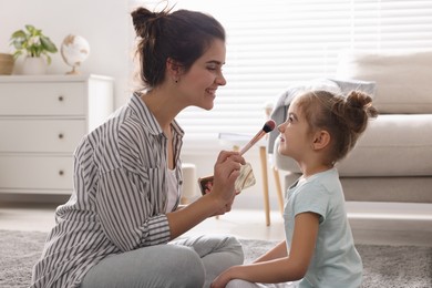 Photo of Young mother and her daughter spending time together at home