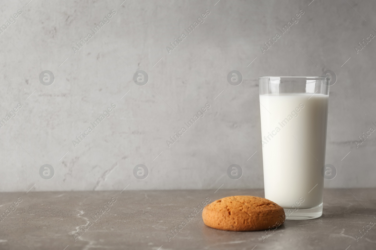 Photo of Glass of milk with oatmeal cookie on table. Fresh dairy product