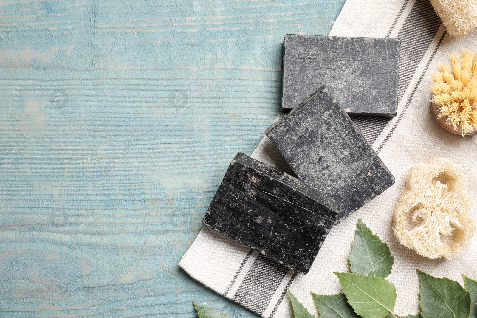 Photo of Flat lay composition with natural tar soap on wooden table, space for text