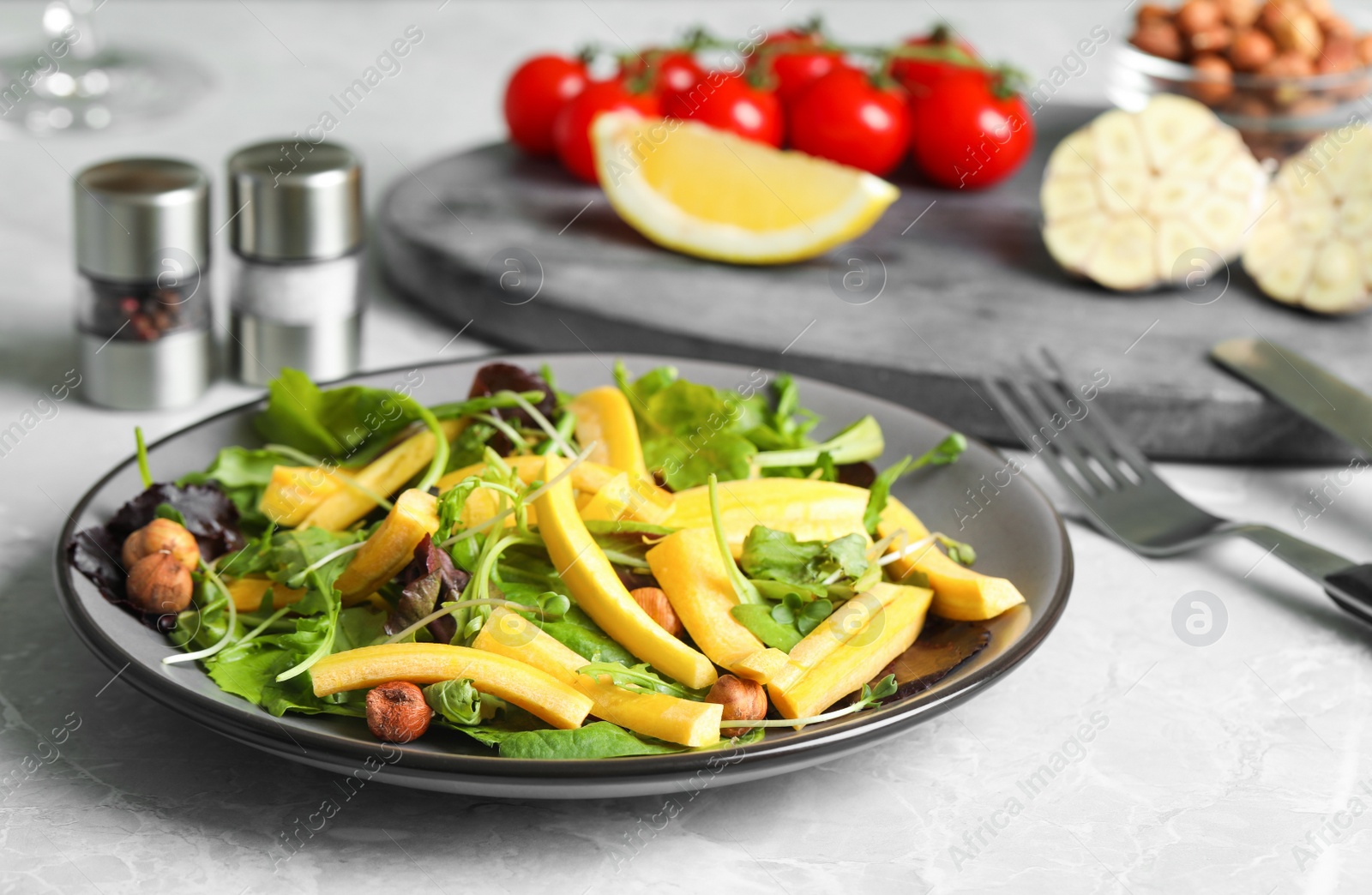 Photo of Delicious fresh carrot salad served on grey marble table, closeup