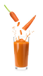 Image of Fresh cut carrot falling into glass of juice with splashes on white background