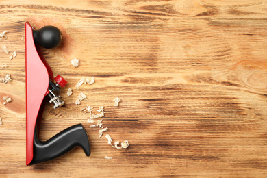 Modern jack plane and shavings on wooden background, top view with space for text. Carpenter's tool