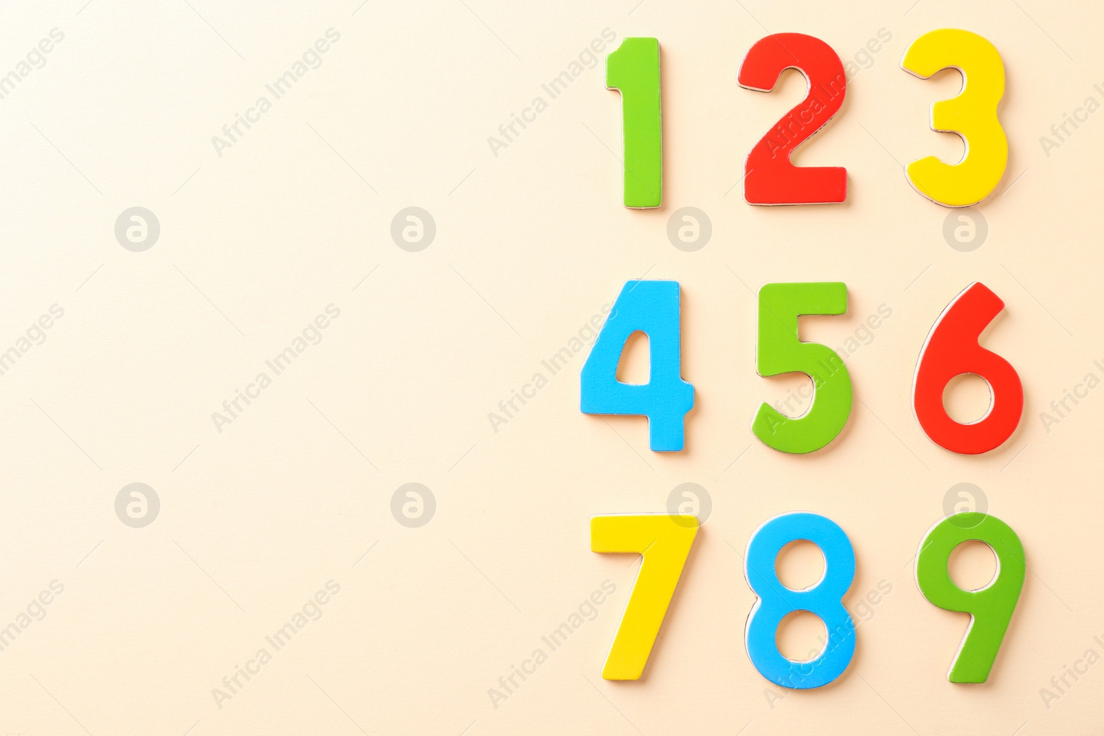 Photo of Colorful numbers on beige background, flat lay. Space for text