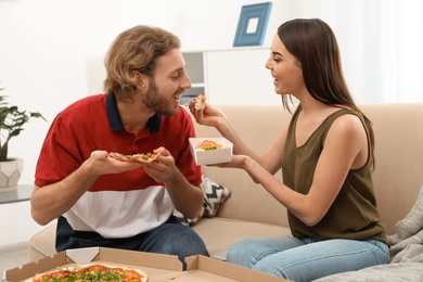 Photo of Young couple having lunch in living room. Food delivery