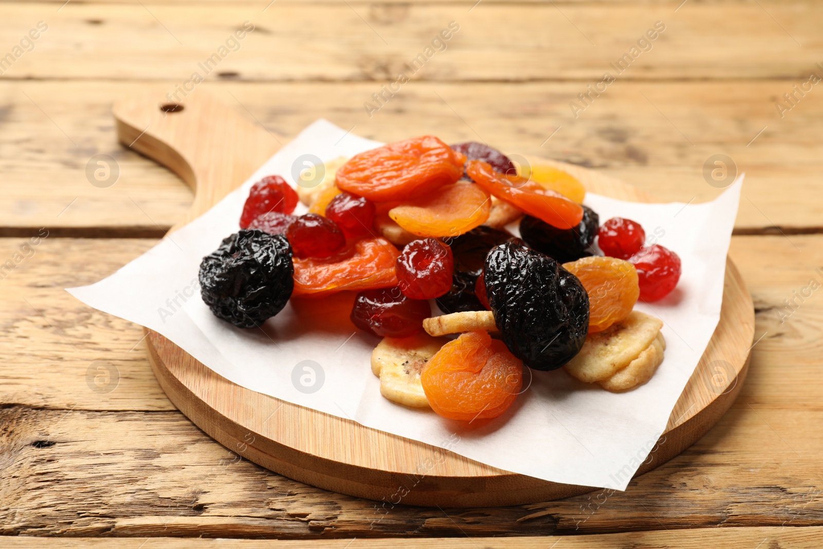 Photo of Mix of delicious dried fruits on wooden table