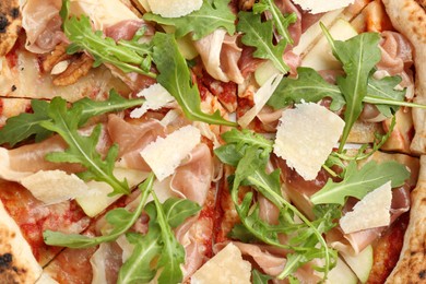 Tasty pizza with meat and arugula as background, top view