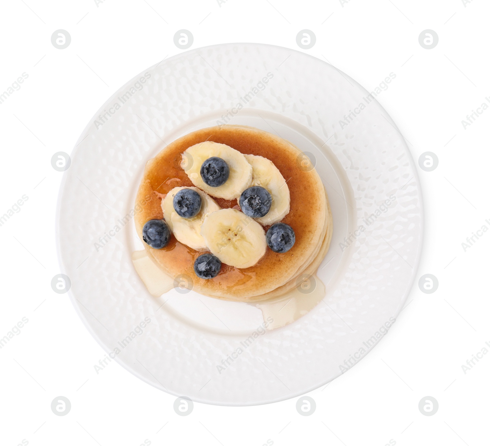 Photo of Delicious pancakes with banana slices, blueberries and honey isolated on white, top view