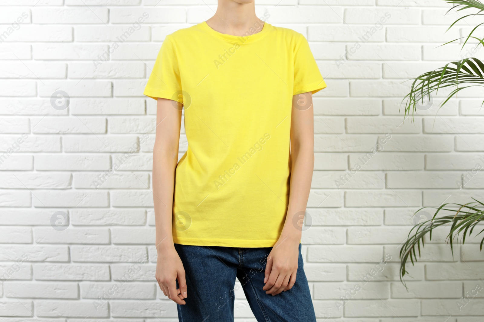 Photo of Woman in bright t-shirt near brick wall. Mock up for design