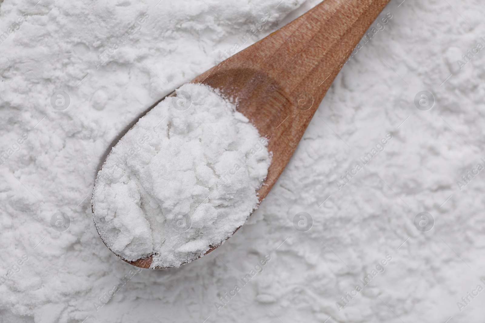 Photo of Heap of natural starch and wooden spoon, top view