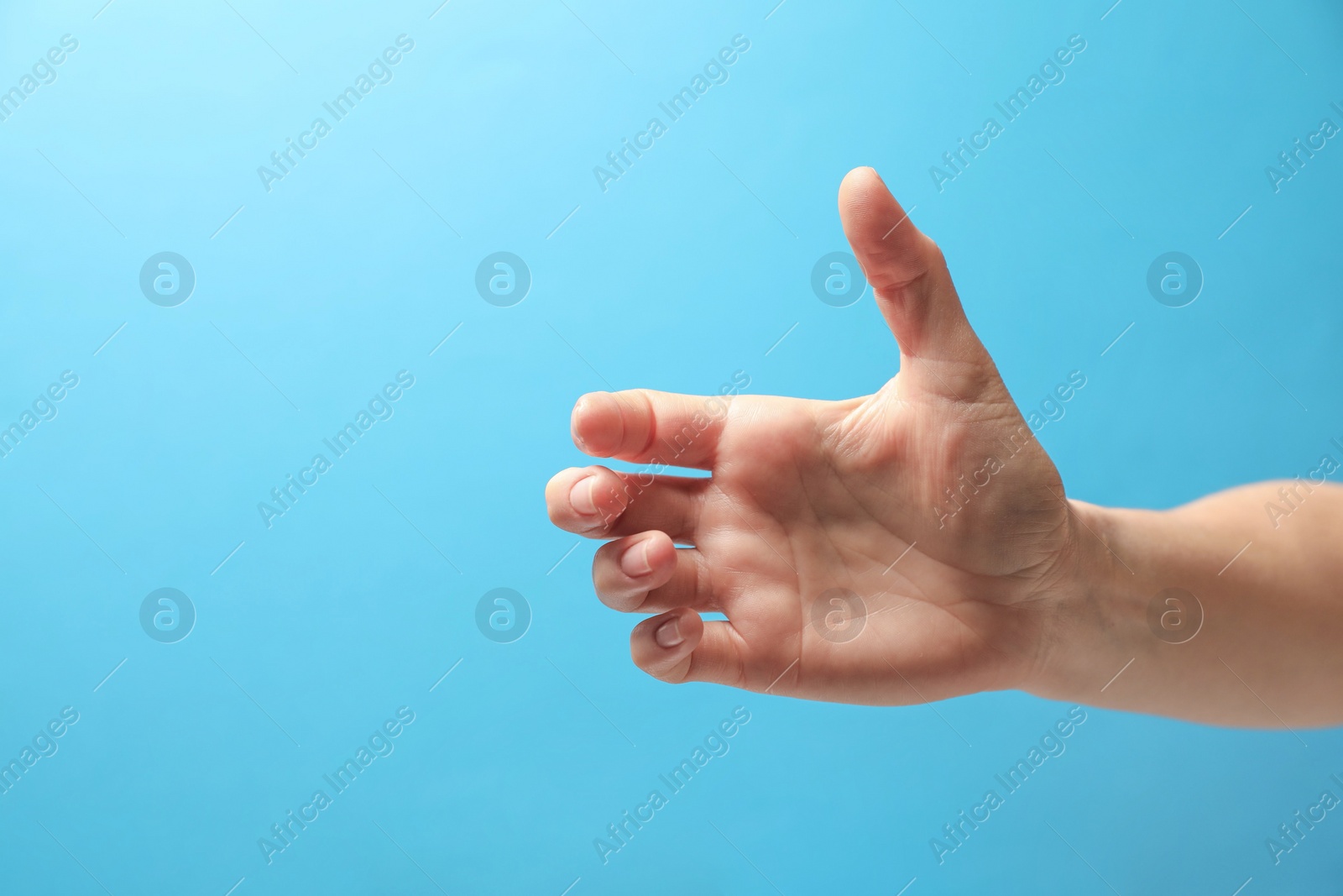 Photo of Woman holding something in hand on light blue background, closeup. Space for text