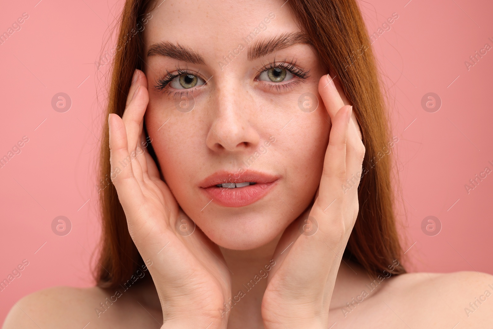 Photo of Portrait of beautiful woman with freckles on pink background, closeup