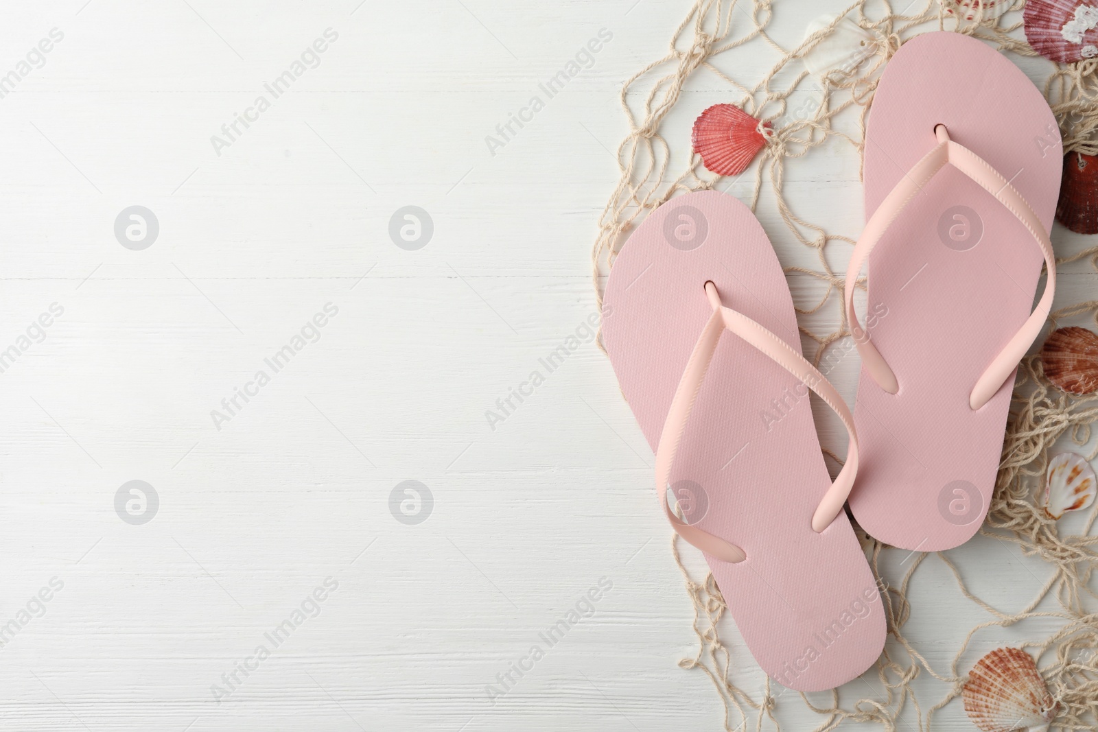 Photo of Flat lay composition with flip flops on wooden background, space for text. Beach objects