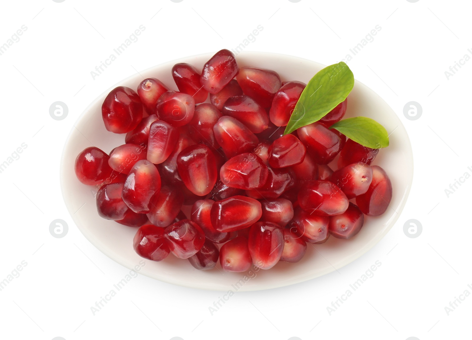 Photo of Ripe juicy pomegranate grains and leaves in bowl isolated on white, top view