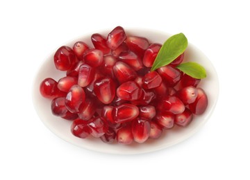 Photo of Ripe juicy pomegranate grains and leaves in bowl isolated on white, top view