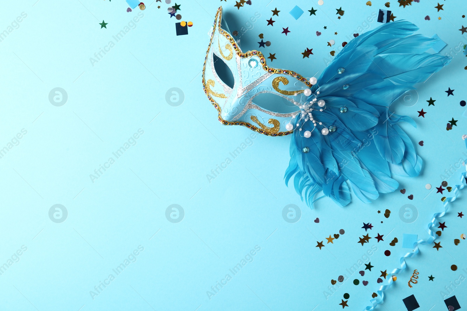 Photo of Beautiful carnival mask with decor on light blue background, flat lay. Space for text