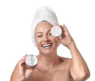 Portrait of beautiful mature woman with perfect skin holding jars of cream on white background