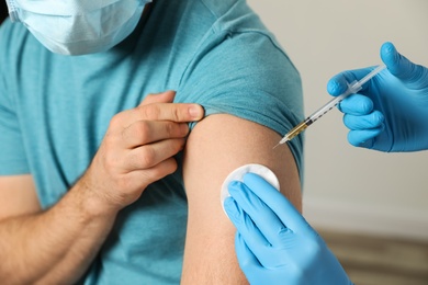 Doctor giving injection to patient in hospital, closeup. Vaccination day