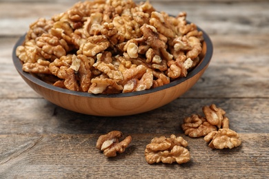 Photo of Plate with tasty walnuts on wooden table