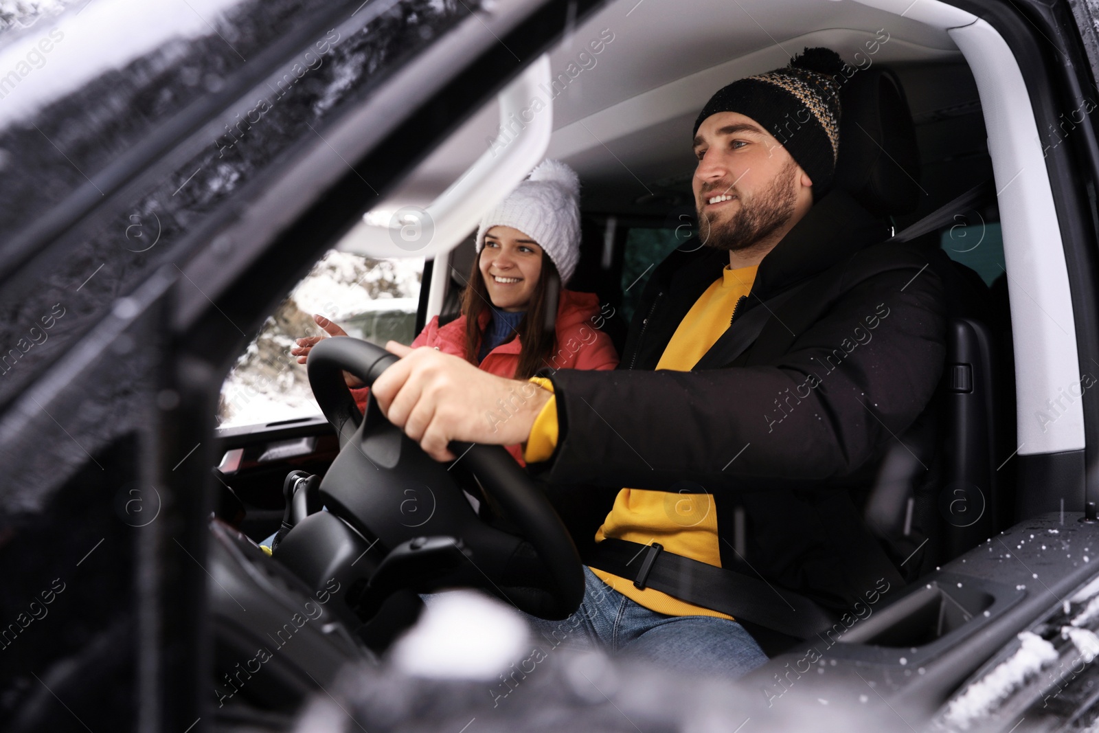 Photo of Young couple traveling by car, view through window. Winter vacation