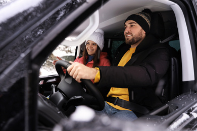 Young couple traveling by car, view through window. Winter vacation