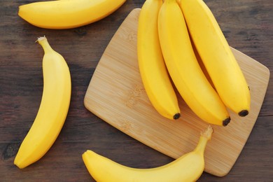 Delicious bananas on wooden table, flat lay