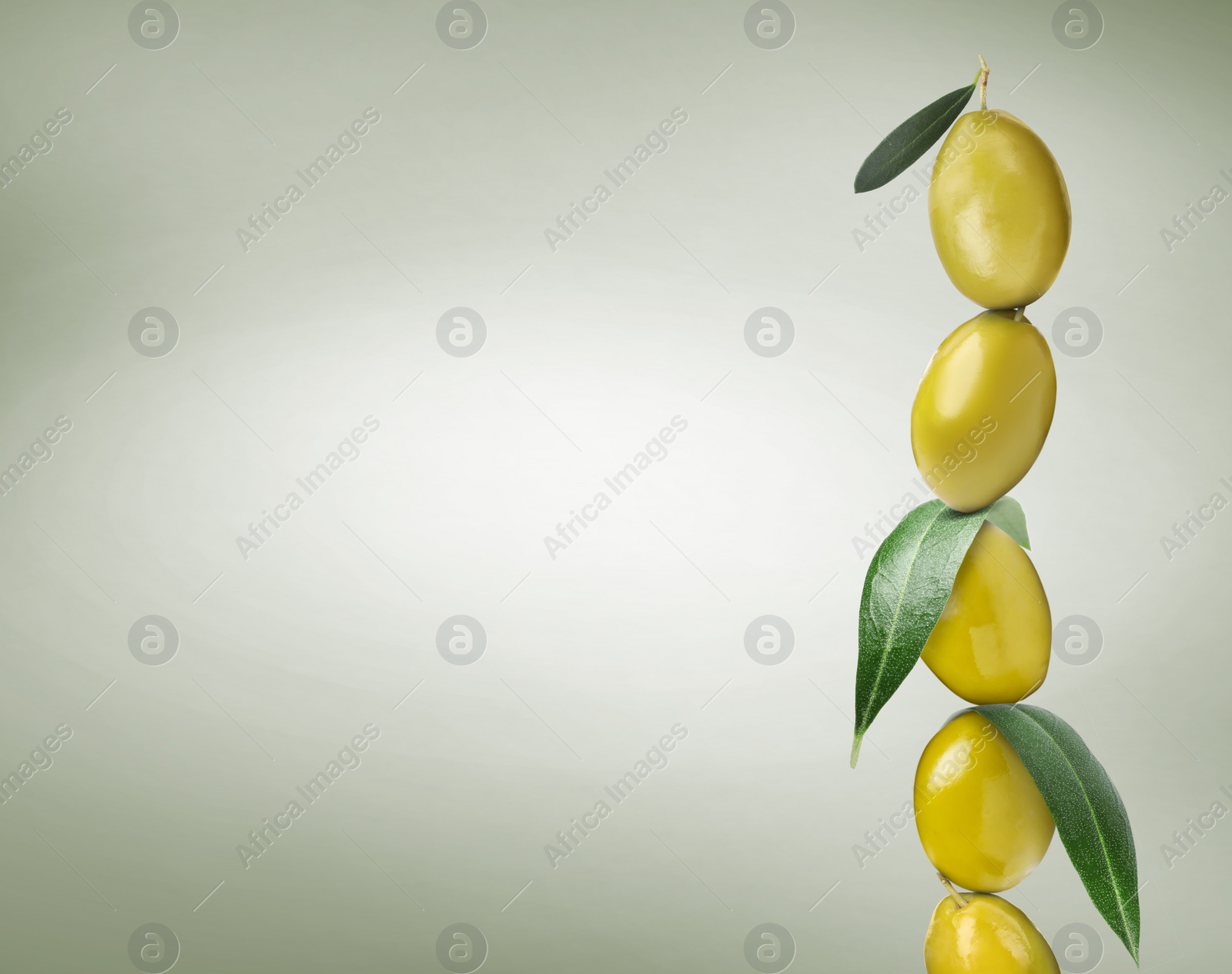 Image of Whole olives with leaves on pastel dusty green background, space for text