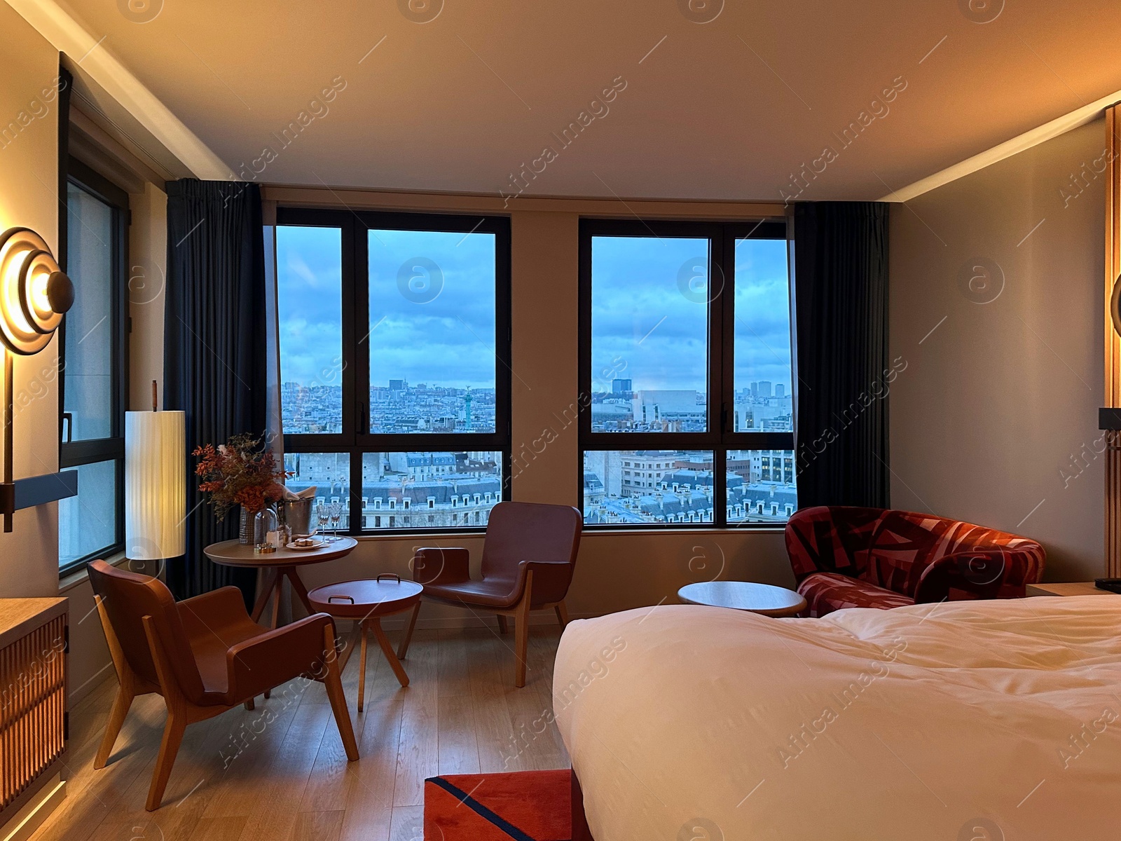 Photo of Stylish hotel room interior with large bed, lamp and table