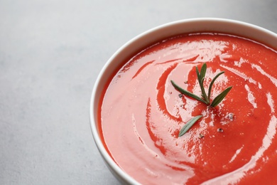 Bowl with fresh homemade tomato soup and space for text on grey background, closeup