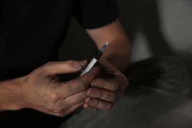 Male drug addict with syringe, closeup of hands