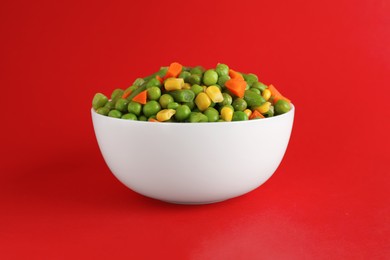 Photo of Mix of fresh vegetables in bowl on red background