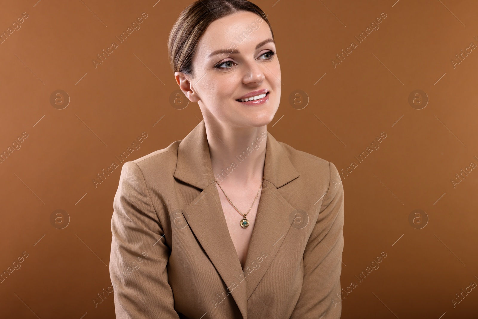 Photo of Beautiful woman with elegant necklace on brown background