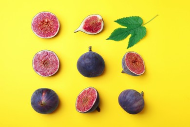 Photo of Fresh ripe figs with green leaf on yellow background, flat lay