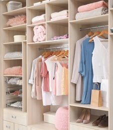 Stylish clothes, shoes and accessories in large wardrobe closet